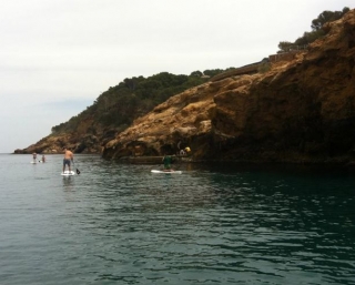 practicando sup con las rocas rodeandoles